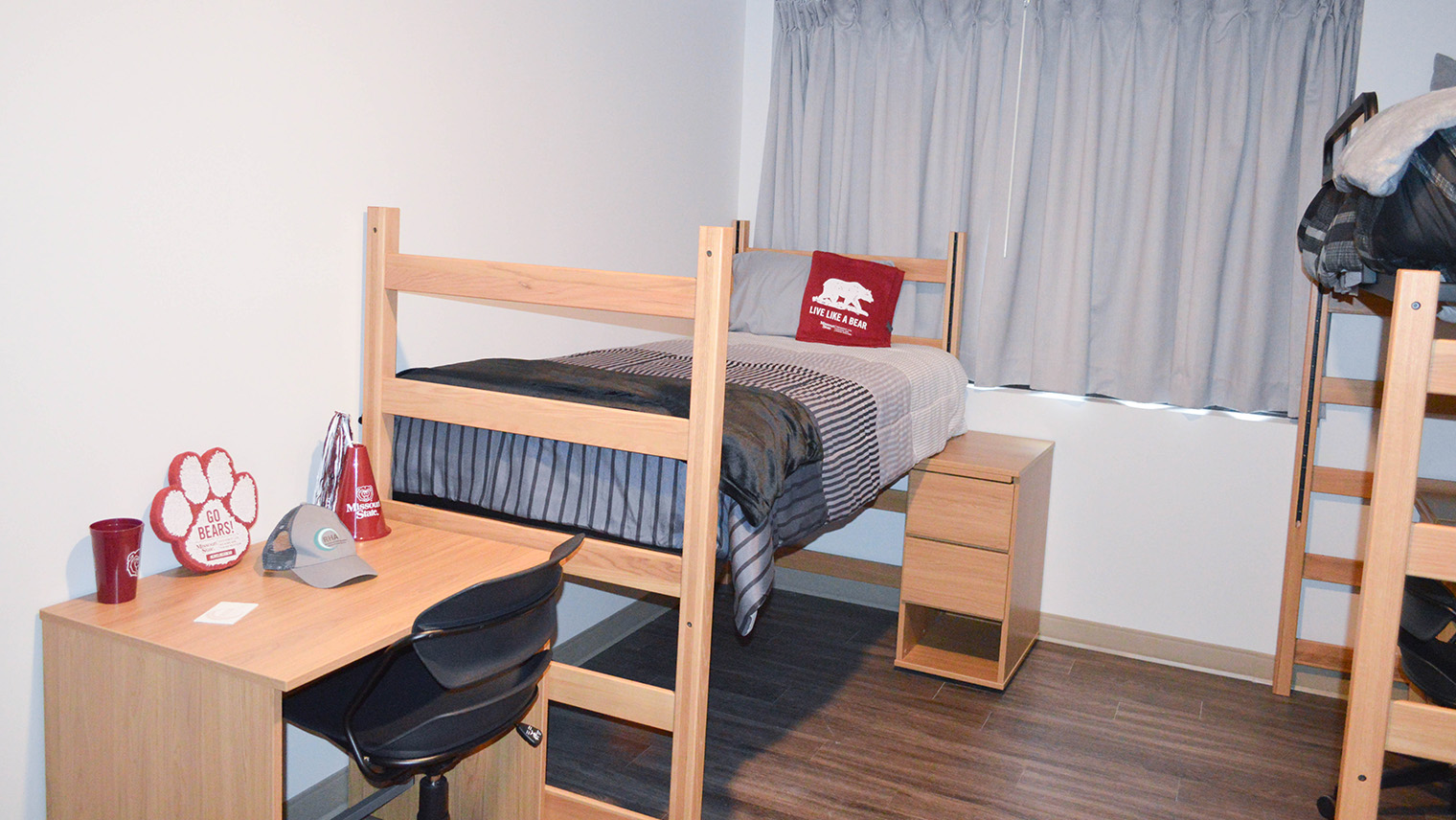 Heitz House student room with beds with adjustable height desks and chairs