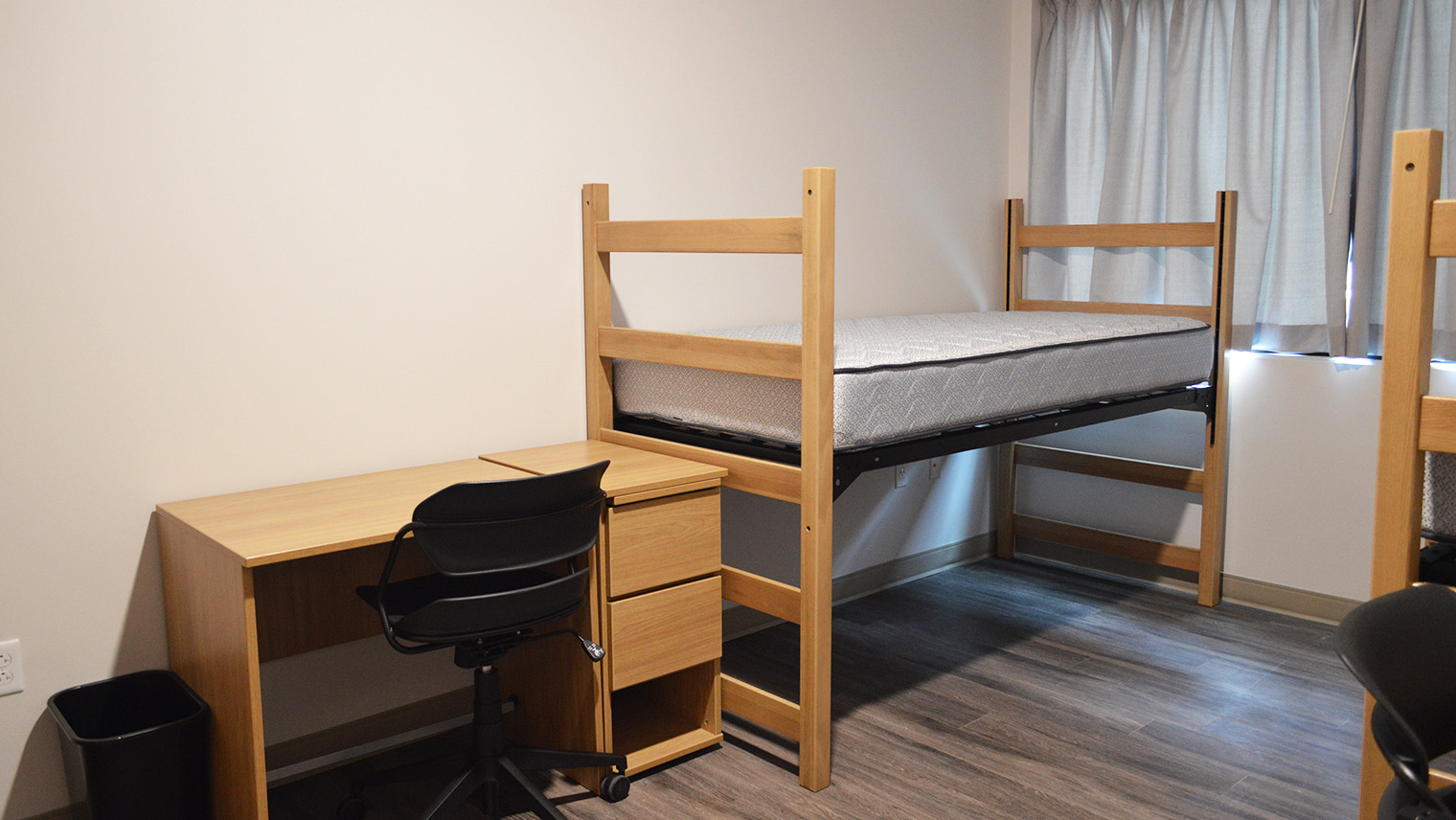 Heitz House student room with beds with adjustable height desks and chairs