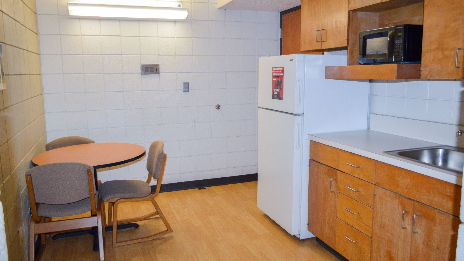 Hutchens 4-person suite kitchen and dining area with table and 4 chairs refrigerator microwave sink 