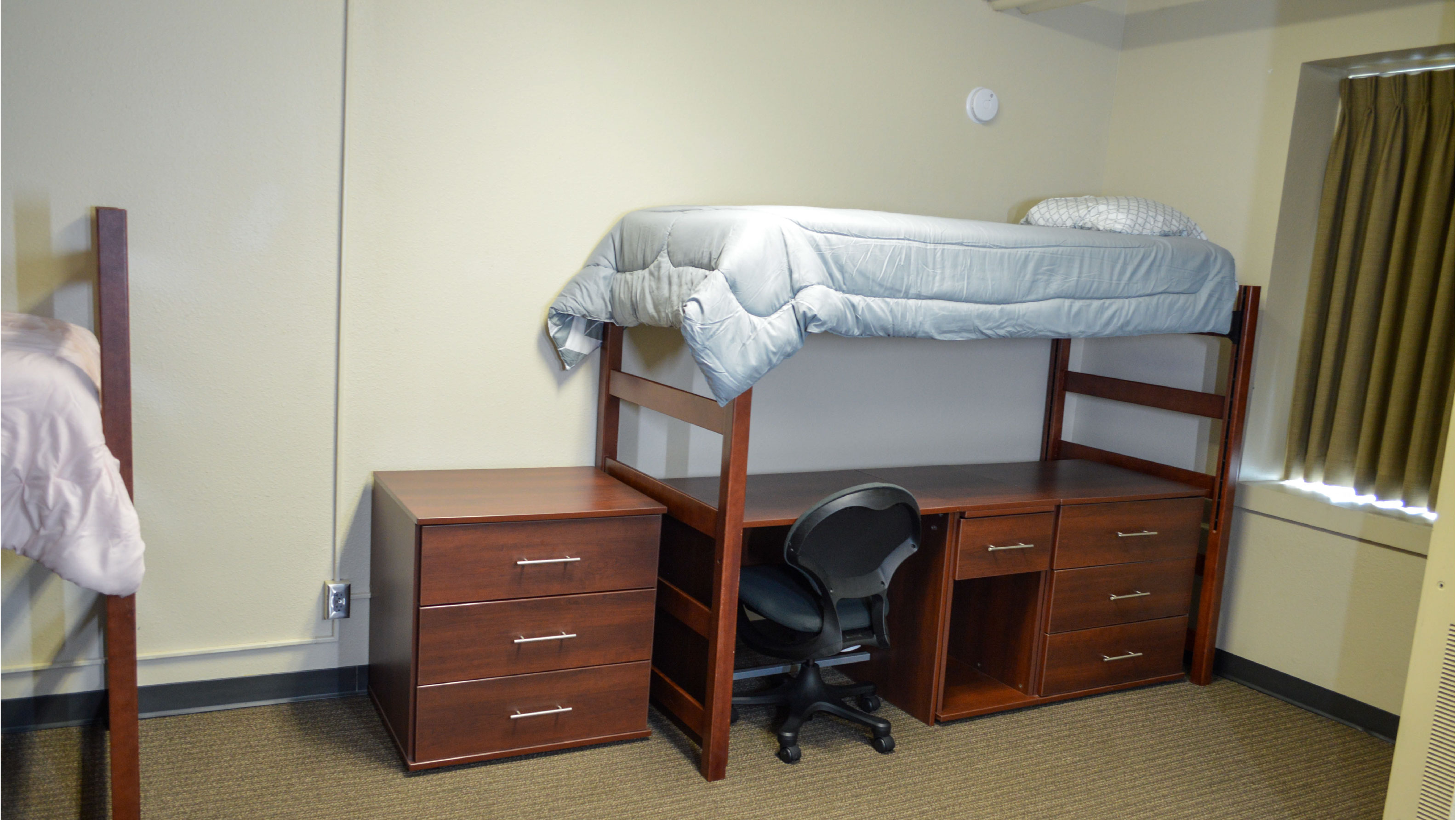 Bedroom with lofted bed desk and set of drawers