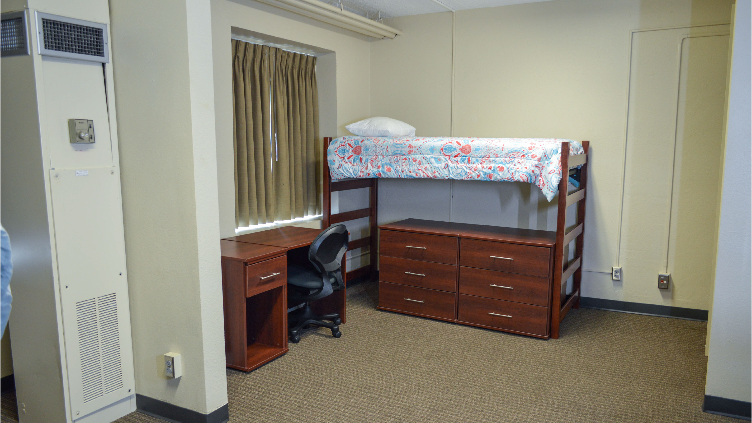Bedroom with lofted bed desk and set of drawers