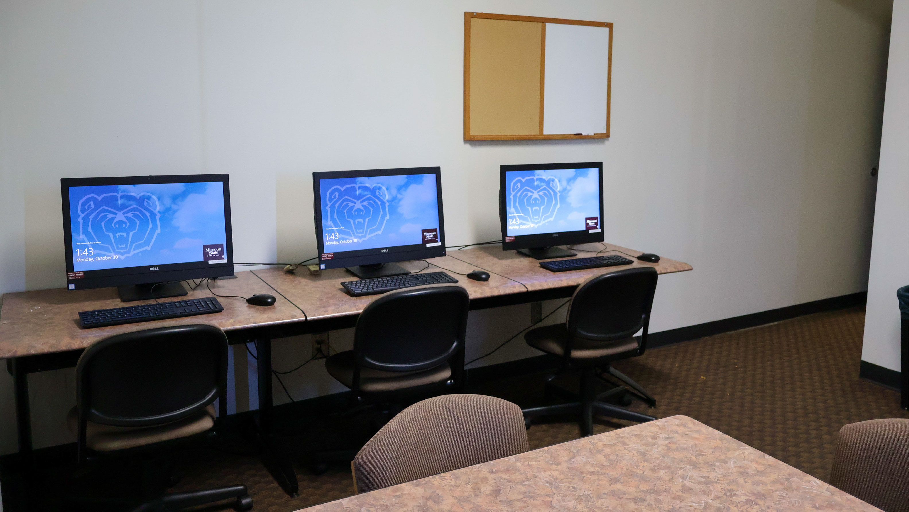 computer lab with 3 desktop computers and chairs