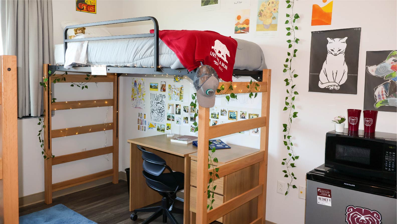 Heitz bedroom with lofted bed and desk with chair underneath and mini fridge and microwave beside