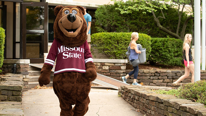 Boomer Bear walking in front of Freddy during move-in