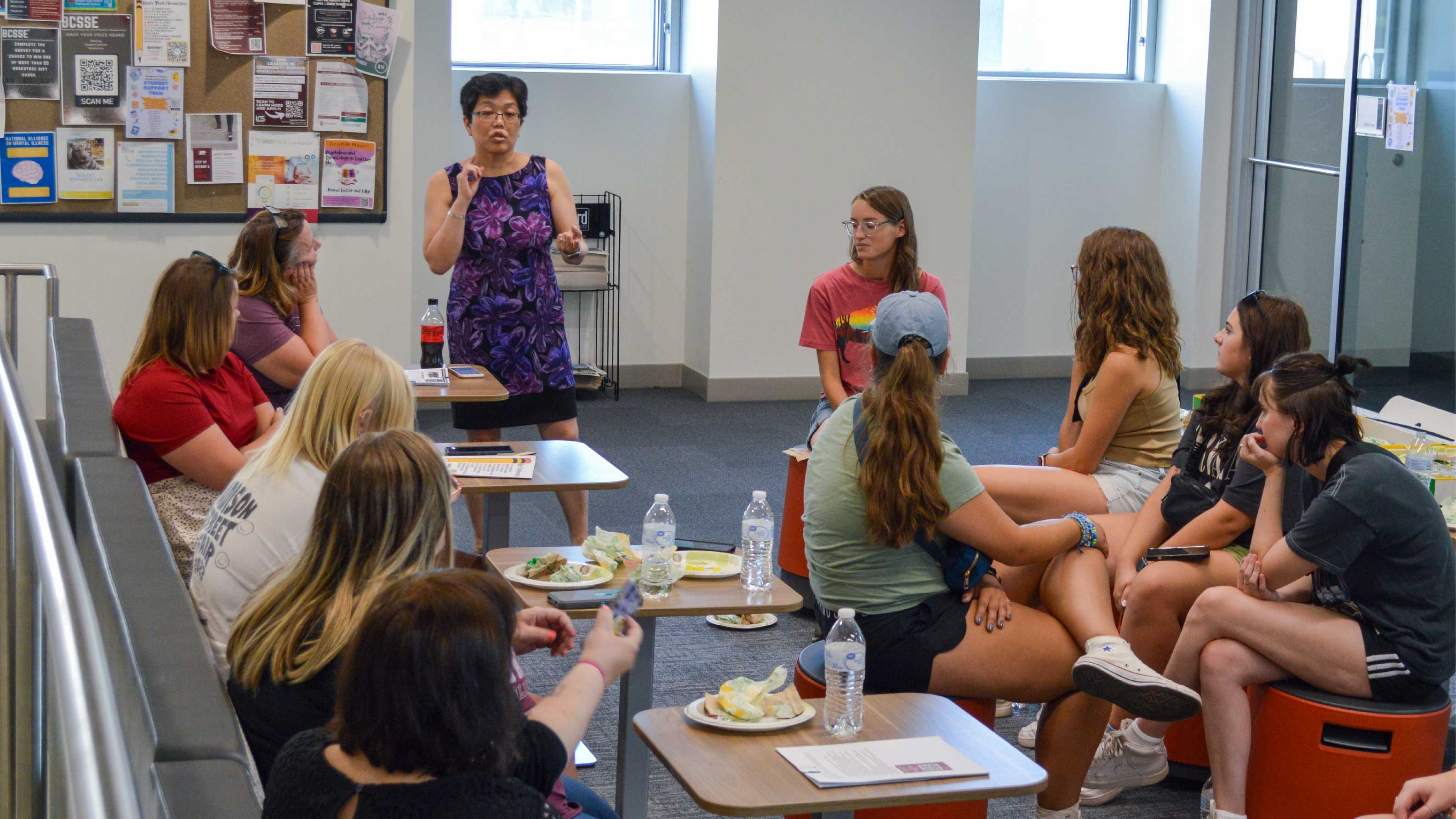 partner talking to group of students