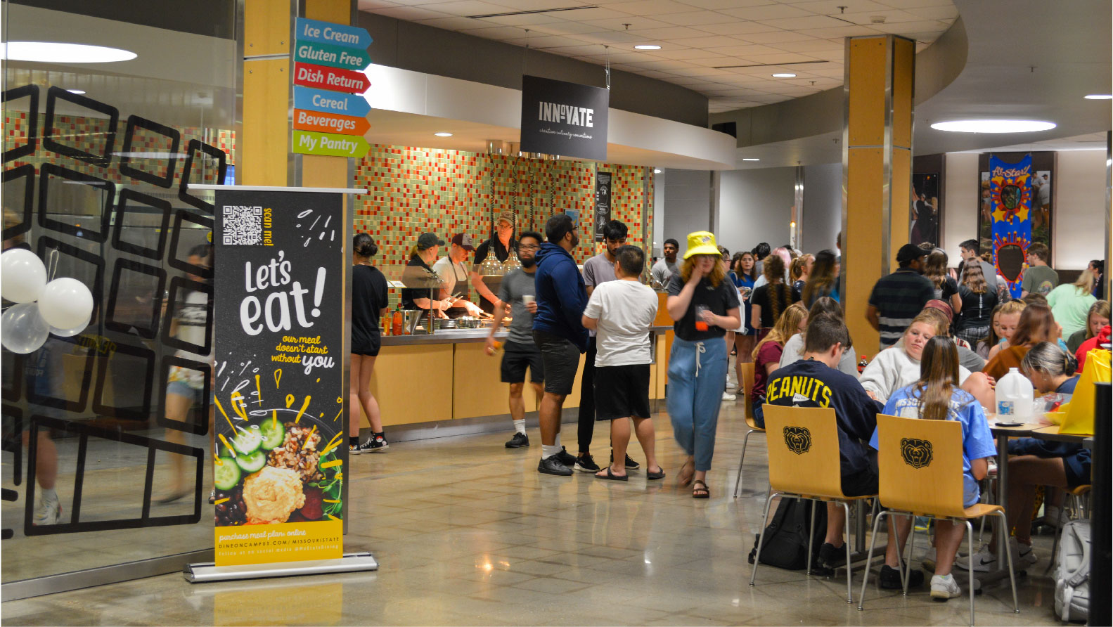 student sitting eating and standing in line