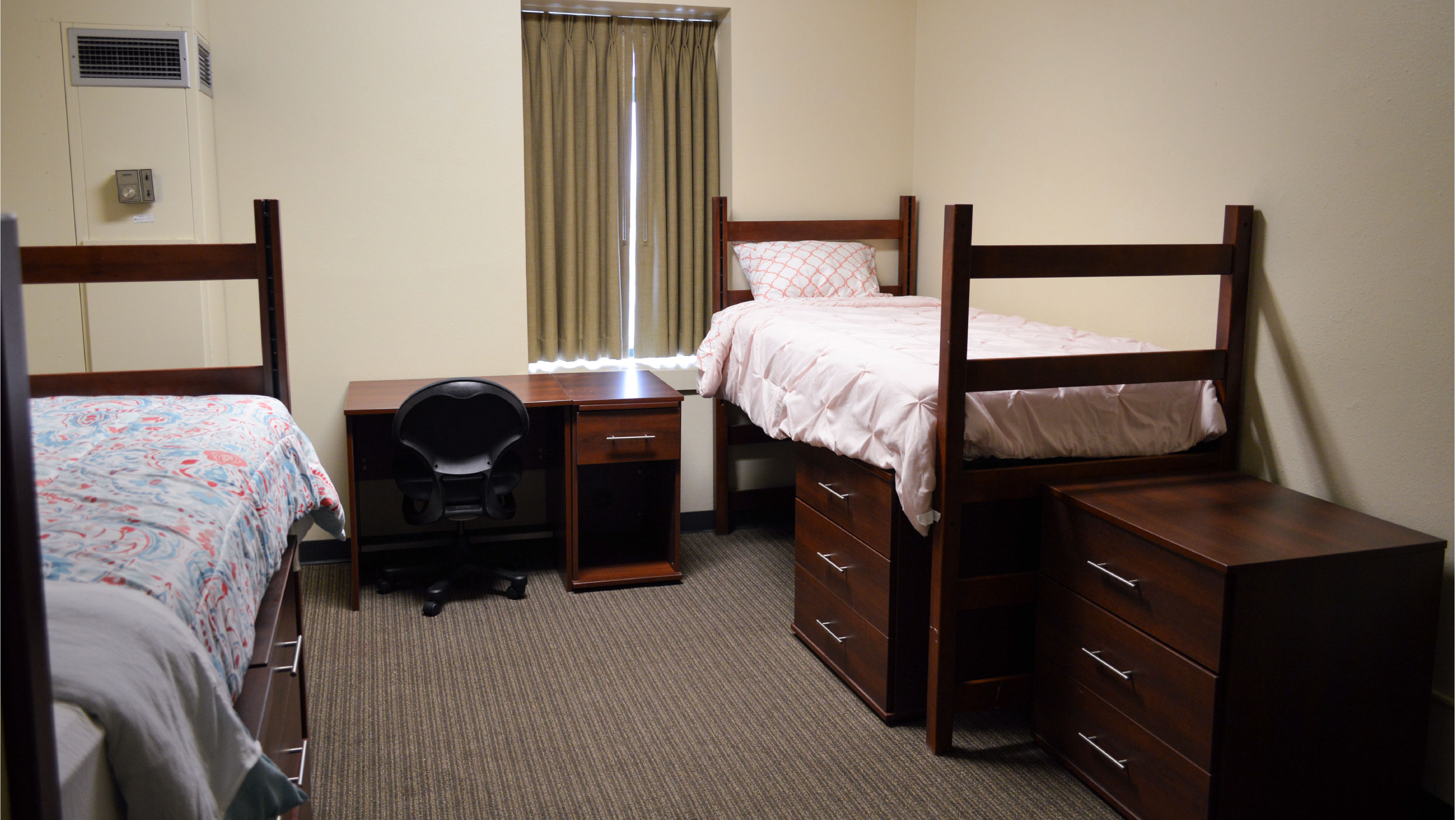 Room with two beds desks and set of drawers