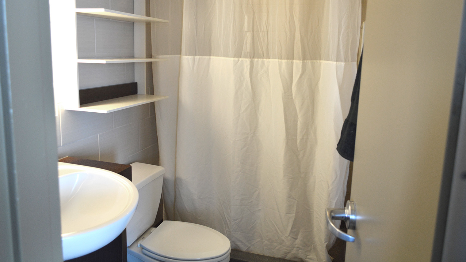 bathroom with shower shower curtain toilet sink and storage