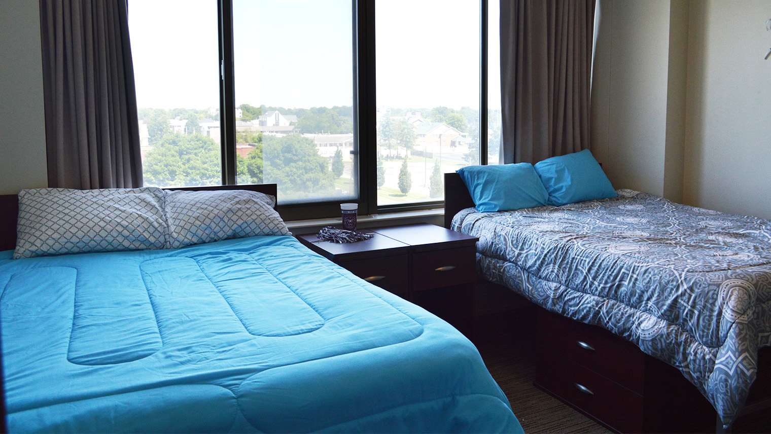 bedroom with two beds two bedside tables and under bed storage and closets