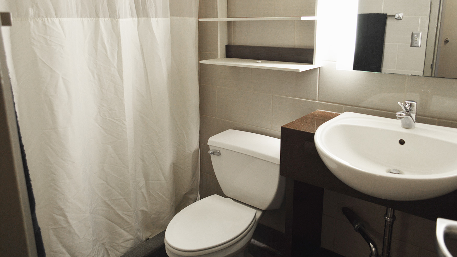 Bathroom with toilet sink shower shower curtain and storage cabinet