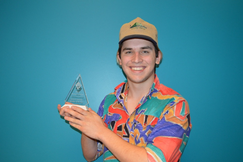 NRHH member pictured in front of a blue background holding an award
